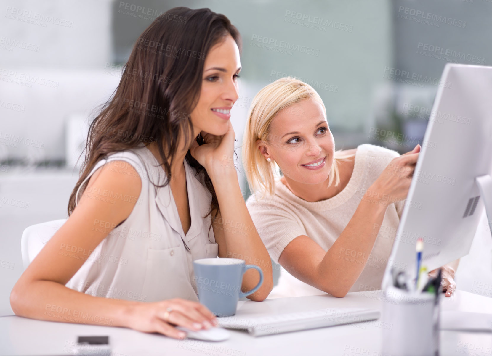 Buy stock photo Two businesswomen conferring with one another on a project