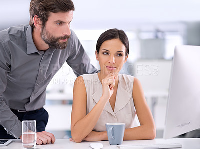Buy stock photo Two businesspeople conferring with one another on a project