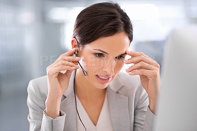 Buy stock photo An attractive call center agent struggling to help a client