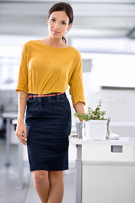 Buy stock photo A beautiful young businesswoman standing alongside her desk in the office