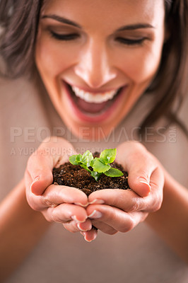 Buy stock photo Cropped shot of a beautiful young woman holding a tiny plant in her hands