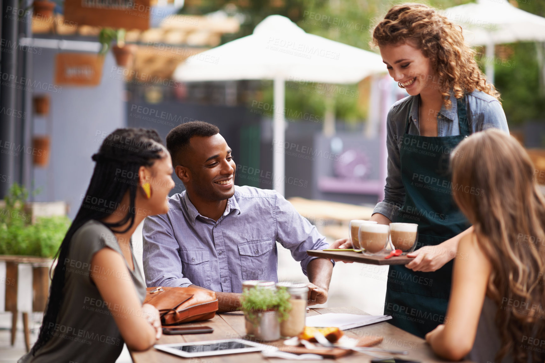 Buy stock photo Cropped shot of a waitress serving her customers at a coffee shop