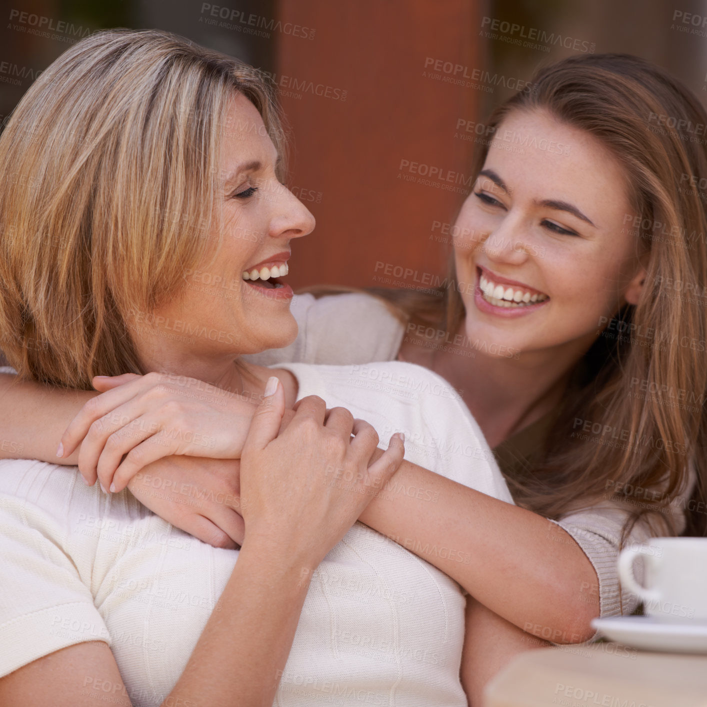 Buy stock photo Happy, mother and daughter embrace for love, laughing and care. Woman, smiling and connection with family, bonding and tea break for lunch sitting and excited for positive news at home together 