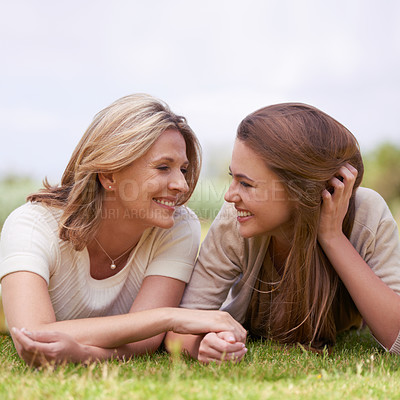 Buy stock photo A loving mother and daughter lying side by side on the grass