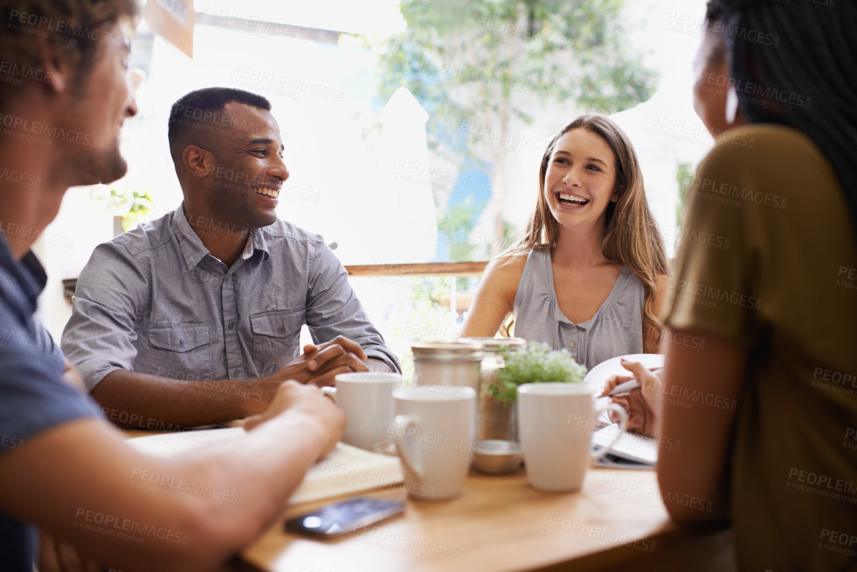 Buy stock photo Shot of a group of friends talking in a cafe