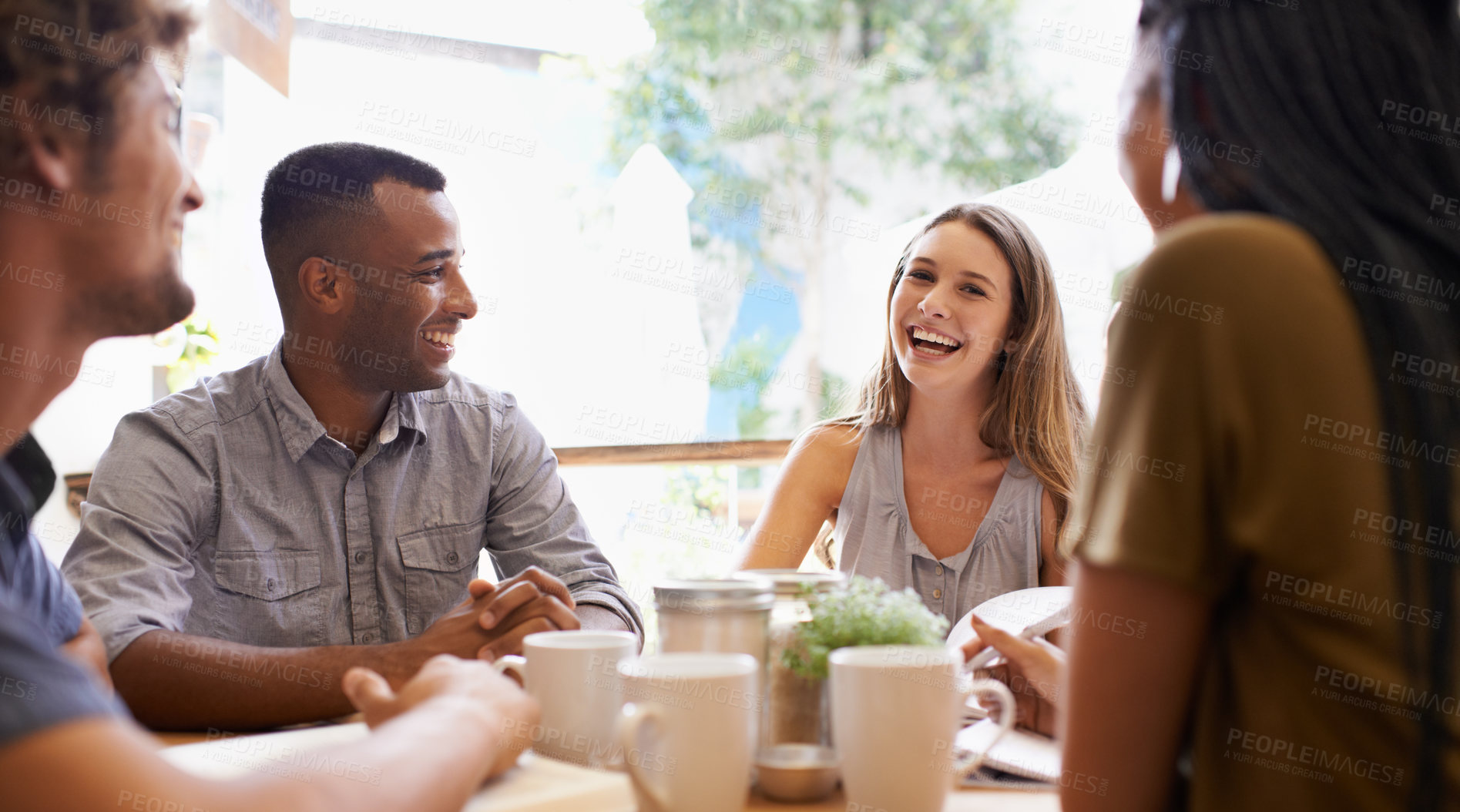 Buy stock photo Shot of a group of friends talking in a cafe