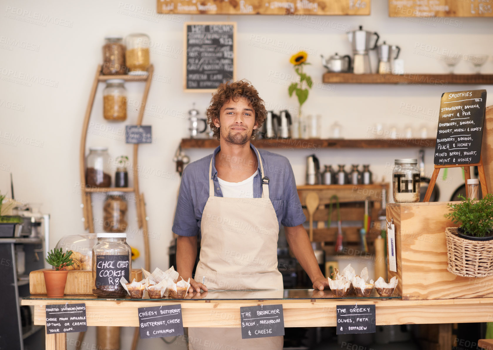 Buy stock photo Portrait of a male barista standing at a cafe counter