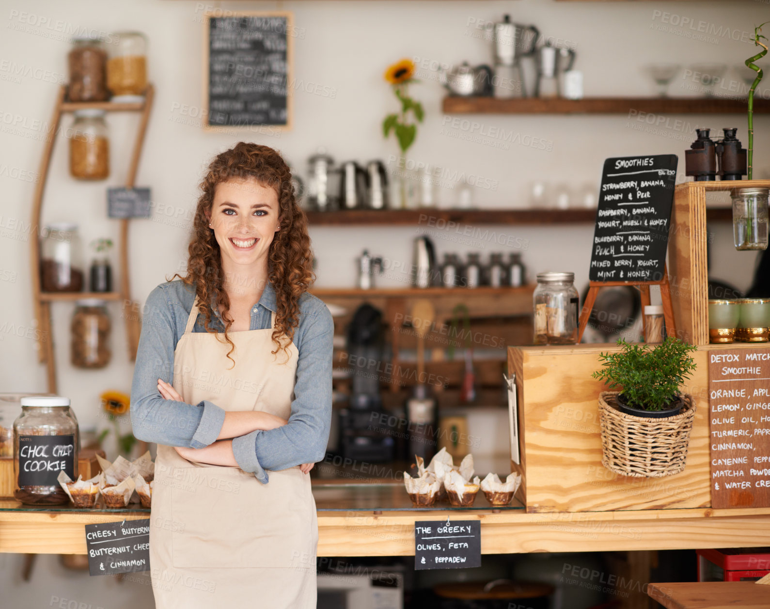 Buy stock photo Portrait of an attractive young barista starting at a cafe counter