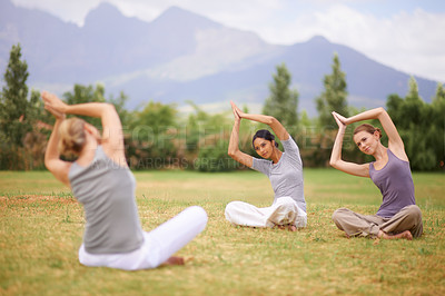 Buy stock photo Woman, personal trainer and yoga class on field in nature for spiritual wellness, namaste or wellbeing. Young female person, yogi or fitness teacher with group in zen or balance for outdoor exercise