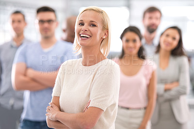 Buy stock photo Shot of a smiling businesswoman standing in front of her coworkers