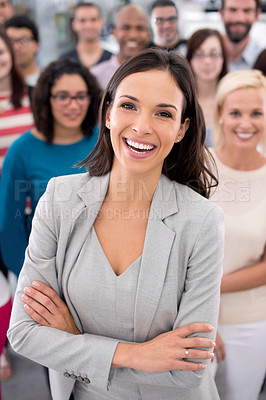 Buy stock photo Shot of a positive businesswoman standing in front of her coworkers