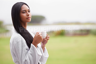 Buy stock photo A beautiful young woman enjoying a cup of coffee while wearing a bathrobe