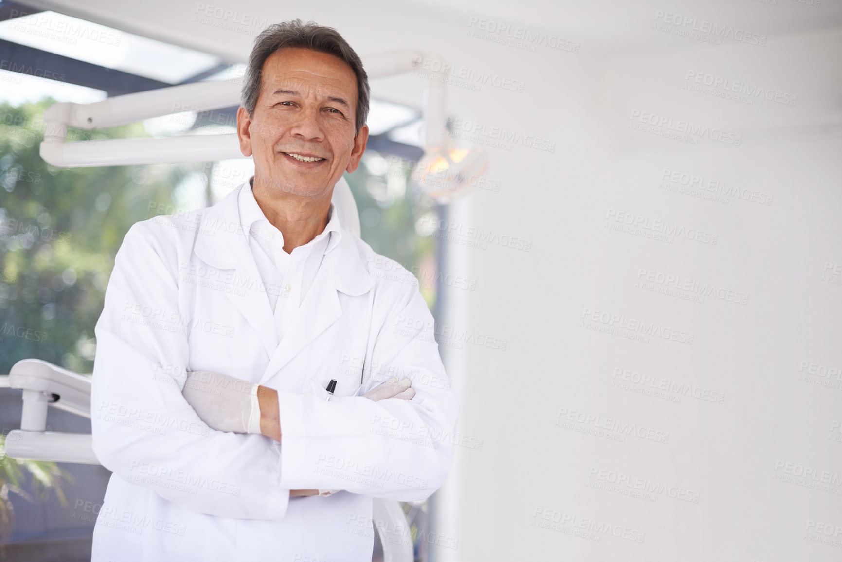 Buy stock photo Portrait of a mature male dental surgeon standing in his office