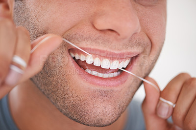 Buy stock photo Cropped shot of a man flossing his teeth