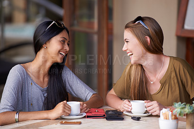 Buy stock photo Two attractive young woman enjoying a coffee at a bistro