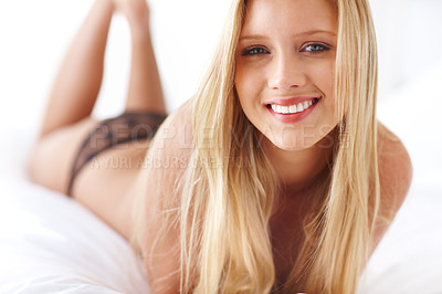 Buy stock photo Portrait of a beautiful topless woman lying on a bed