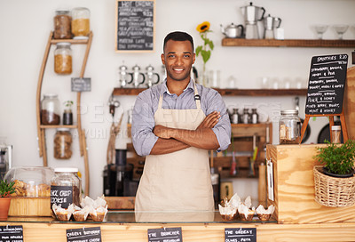 Buy stock photo A handsome young man standing behind the counter of his cafe