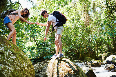 Buy stock photo Hiking, help and couple by river in nature for adventure, freedom and explore with backpack outdoors. Forest, travel and man and woman on mountain for holiday, vacation and trekking for wellness