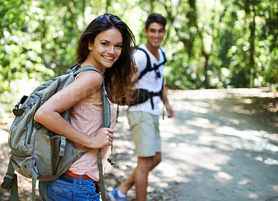 Buy stock photo Shot of a young couple hiking through the forest
