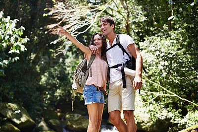 Buy stock photo Hiking, pointing or happy couple hug in nature, forest or park on a trekking adventure on holiday. Man, woman or romantic people in woods for travel or journey with care, love or wellness on vacation