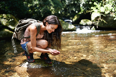 Buy stock photo A young woman stopping for a water break while out hiking in the forest