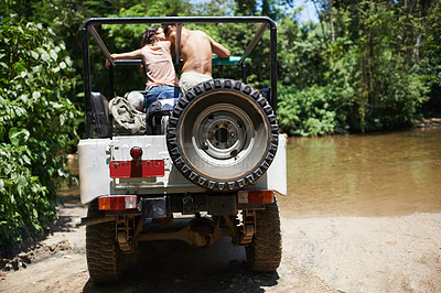 Buy stock photo Couple, forest and adventure with 4x4, drive and outdoor with love, care or nature with river in summer. People, man and woman with back in vehicle, car or journey on road trip in jungle in Colombia