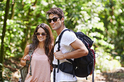 Buy stock photo Happy couple, backpack and hiking with sunglasses in nature for adventure or outdoor journey together. Young man, woman or hiker with smile, bag and bonding for trekking or walk in forest or woods