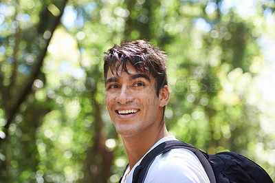 Buy stock photo Shot of a handsome young man hiking in the forest