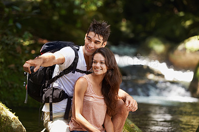Buy stock photo Couple, point and backpack for hiking in jungle with smile for thinking, holiday and search by river. Man, woman and bag for trekking, direction and journey in rainforest for vacation in Colombia