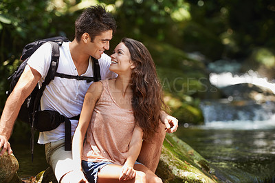 Buy stock photo Couple, hug and vacation for hiking in jungle with smile for thinking, holiday and connection by river. Man, woman and bag for trekking, memory and journey in rainforest for vacation in Colombia