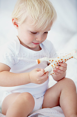 Buy stock photo Baby, kid and playing with giraffe in home nursery, learning and having fun on bed. Toddler, animal and cute child with toy for development, education and childhood of innocent boy in house alone