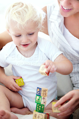 Buy stock photo Shot of a mother and her baby boy playing with building blocks