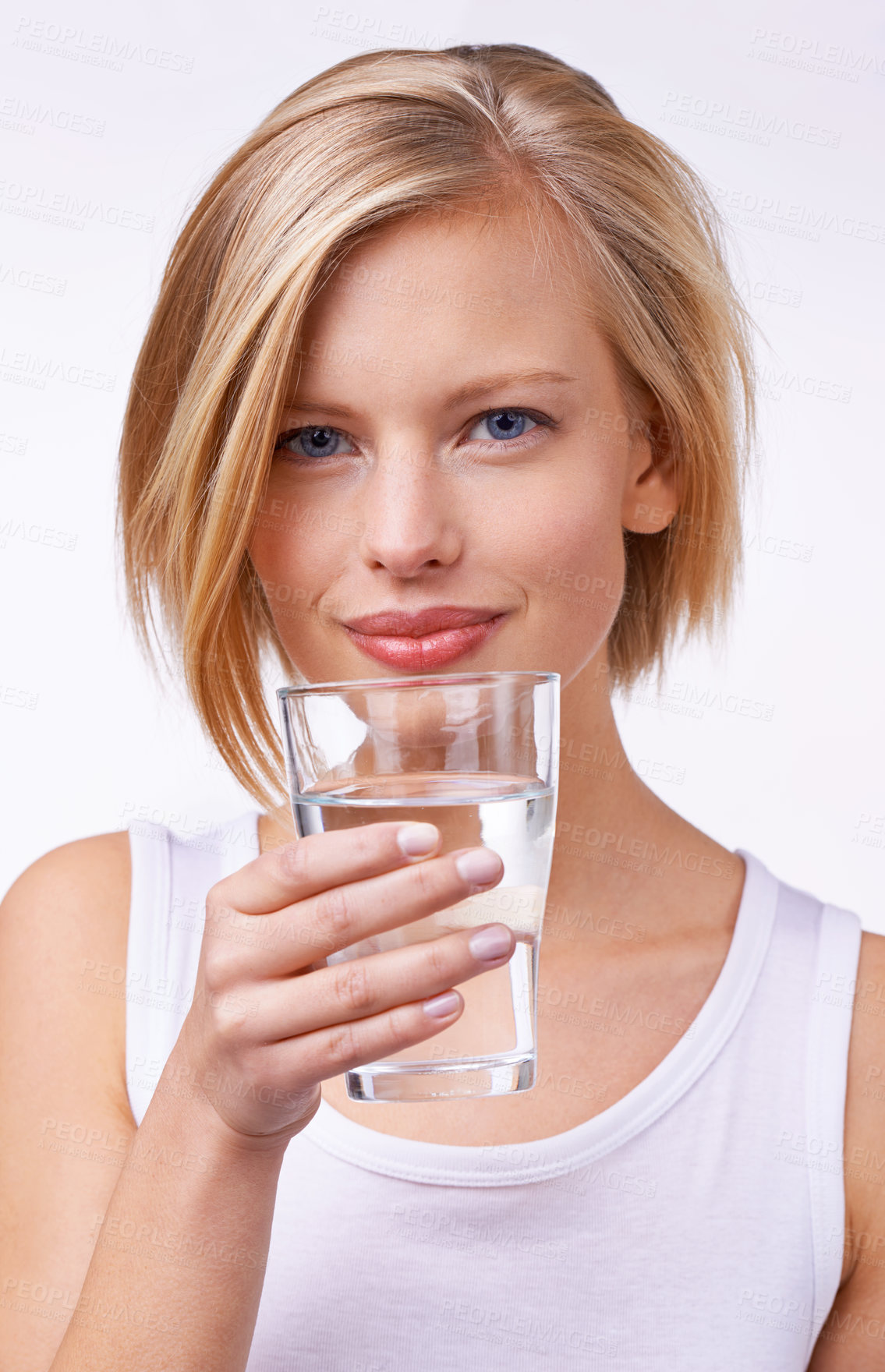 Buy stock photo Studio portrait of a beautiful young woman holding a glass of water