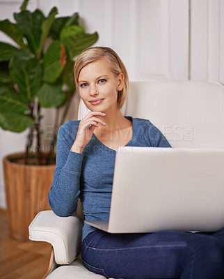 Buy stock photo Portrait of a beautiful woman sitting on a couch using a laptop