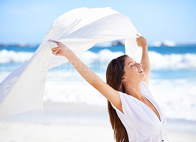 Buy stock photo Sea, happy woman and fabric in wind at beach outdoor for summer, vacation and travel on holiday. Ocean, smile and person fly with silk sarong in the air for adventure, freedom or calm breeze by water