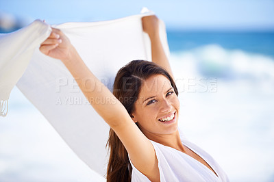 Buy stock photo Portrait, happy woman and sarong in wind at beach outdoor for summer, vacation and travel on holiday. Ocean, smile and person fly with fabric in the air for freedom, breeze and face by water in Spain
