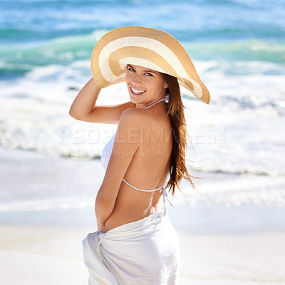 Buy stock photo A beautiful young woman posing in a woven sunhat and sarong at the beach