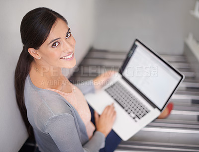 Buy stock photo Portrait of a young woman sitting on stairs using a laptop