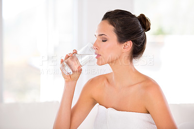 Buy stock photo Home, woman and skincare with drinking water in towel for  routine, treatment and body care in living room. Female person, hydration and smooth with cosmetic for natural glow, soft and confidence. 