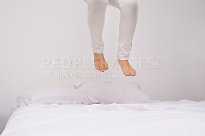 Buy stock photo Jumping, bed and kid with fun, energy and morning in a bedroom with game and feet. Youth, hop and home with a excited child on a duvet in air with crazy play, leap and legs in house with white wall