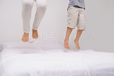 Buy stock photo Jumping, bed and kids with legs, energy and morning in a bedroom with game and feet. Youth, sibling and home with a excited child on duvet in air with crazy play, leap and fun in house with friends