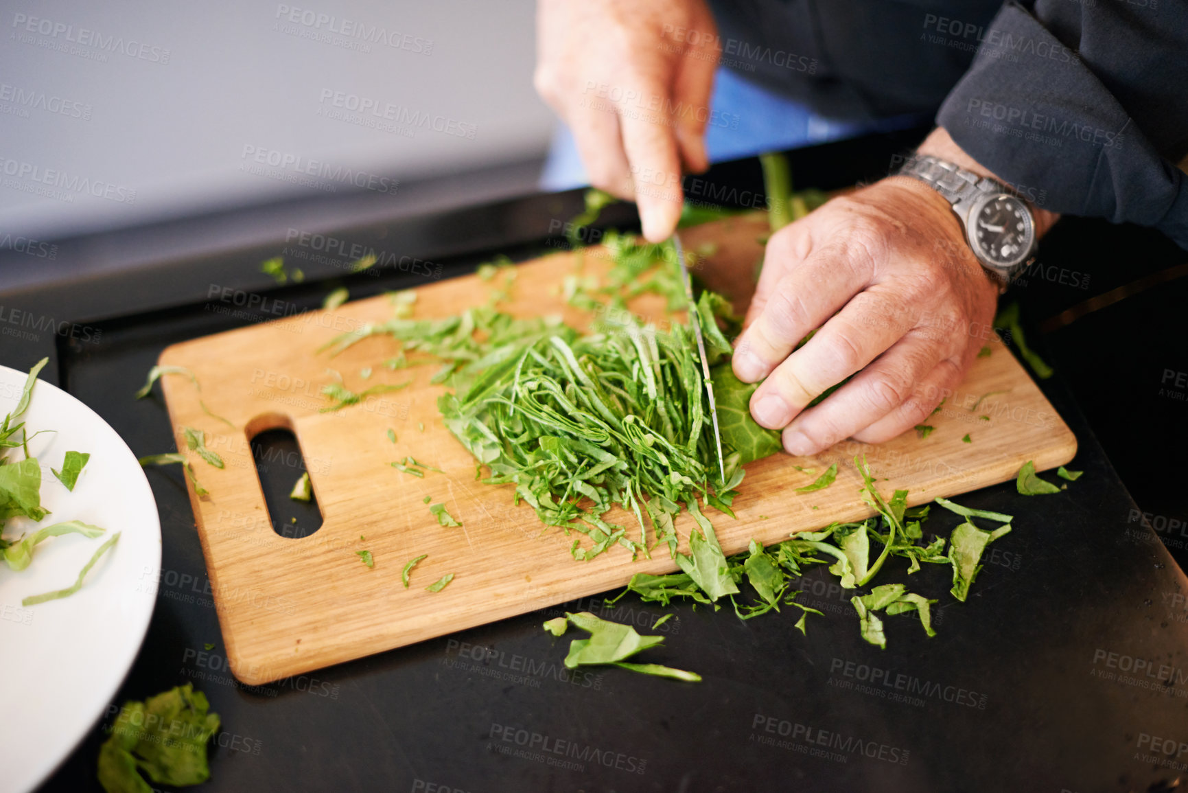 Buy stock photo Hands, salad and chopping board with a man and green leaves for cooking health food in a home. Nutrition, vegan and herb for dinner, vegetables and diet for eating and wellness in kitchen on counter