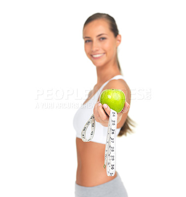 Buy stock photo Hand, apple and measuring tape with a woman in studio isolated on a white background to promote fitness, diet or weight loss. Food, nutrition and measuring with a female athlete holding a green fruit