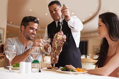 Buy stock photo Couple, waiter and service for dinner in restaurant with meat, happiness and fine dining for anniversary or honeymoon. Man, woman and employee with steak on skewer, healthy meal and table in London