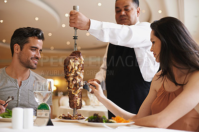 Buy stock photo Couple, waiter and service for lunch in restaurant with meat, happiness and fine dining for anniversary or honeymoon. Man, woman and employee with steak on skewer, healthy meal and table in London