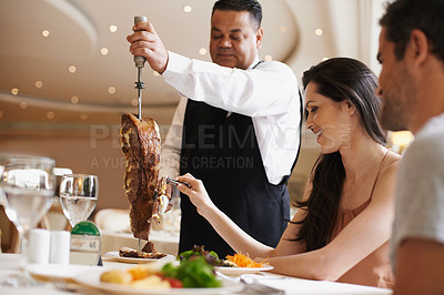 Buy stock photo Couple, waiter and serving for dinner in restaurant with meat, happiness and fine dining for anniversary or honeymoon. Man, woman and employee with steak on skewer, healthy meal and table in London