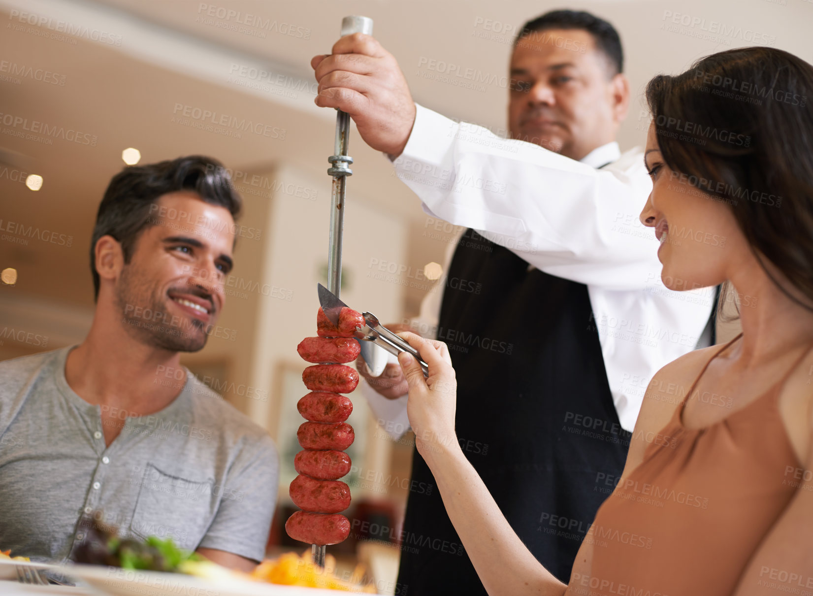 Buy stock photo Food, date and romance with couple in restaurant together for celebration or eating espetada. Love, meat or dinner with happy young man and woman in fine dining hospitality establishment for service