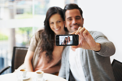 Buy stock photo Cropped shot of an attractive young couple snapping pictures of themselves
