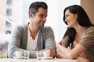 Buy stock photo Love, talking and couple with coffee on date for romance or anniversary in cafeteria. Happy, bonding and young man and woman in conversation drinking latte, espresso or cappuccino at restaurant.