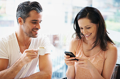 Buy stock photo Shot of a young woman using her mobile phone during a coffee date